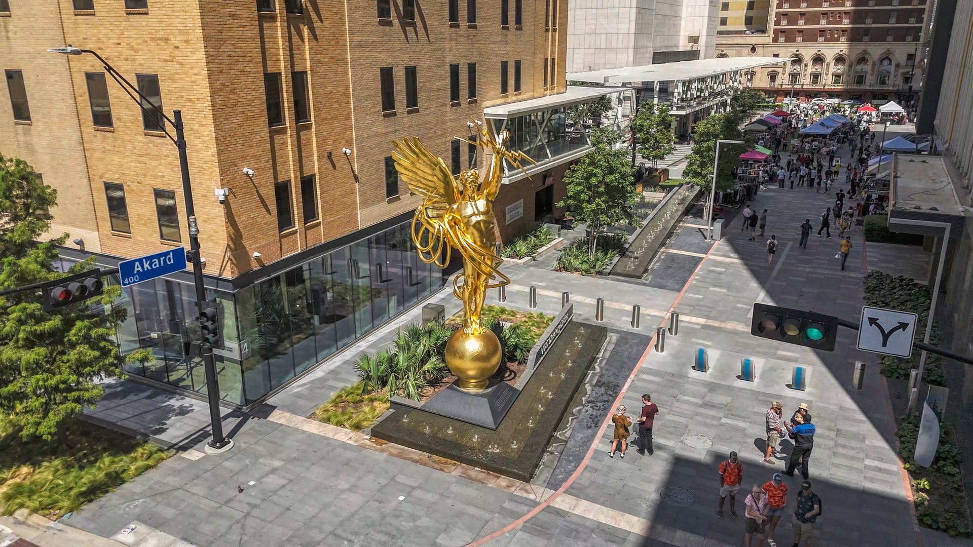 Golden sculpture at the entrance of the Dallas Design District, featuring a striking artistic design in a contemporary urban setting.